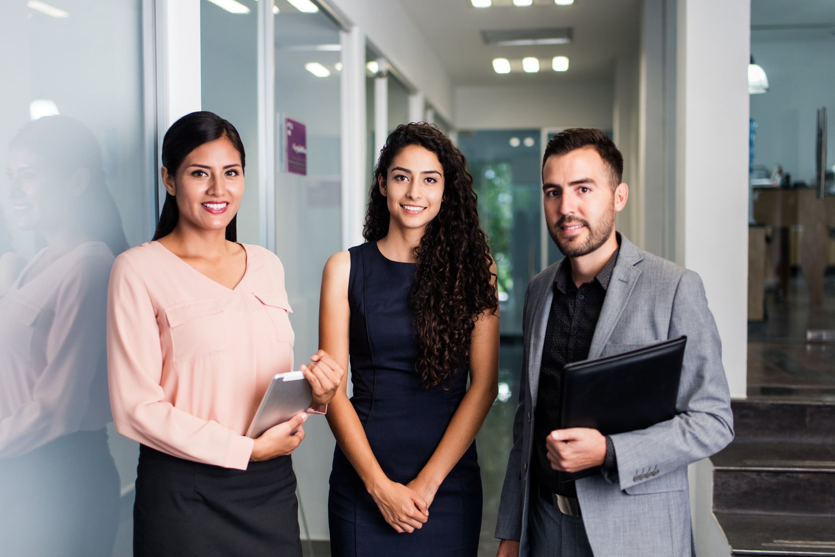 Young executives standing and smiling at camera